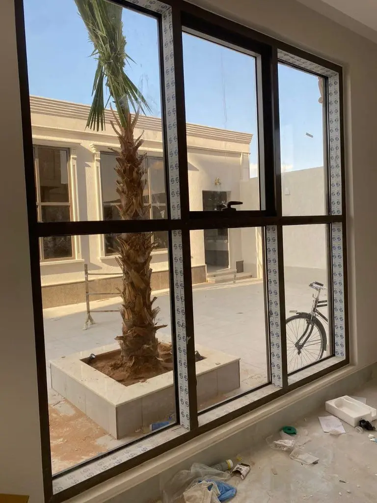 نافذة زجاجية كبيرة بإطار ألمنيوم أسود جدة.