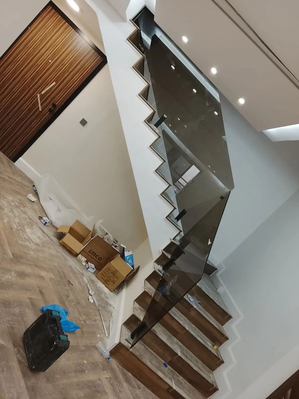 رابزين زجاجي ملون عسلي للدرج مثبت جانبياً على درجات خشبية بتصميم مودرن في جدة.