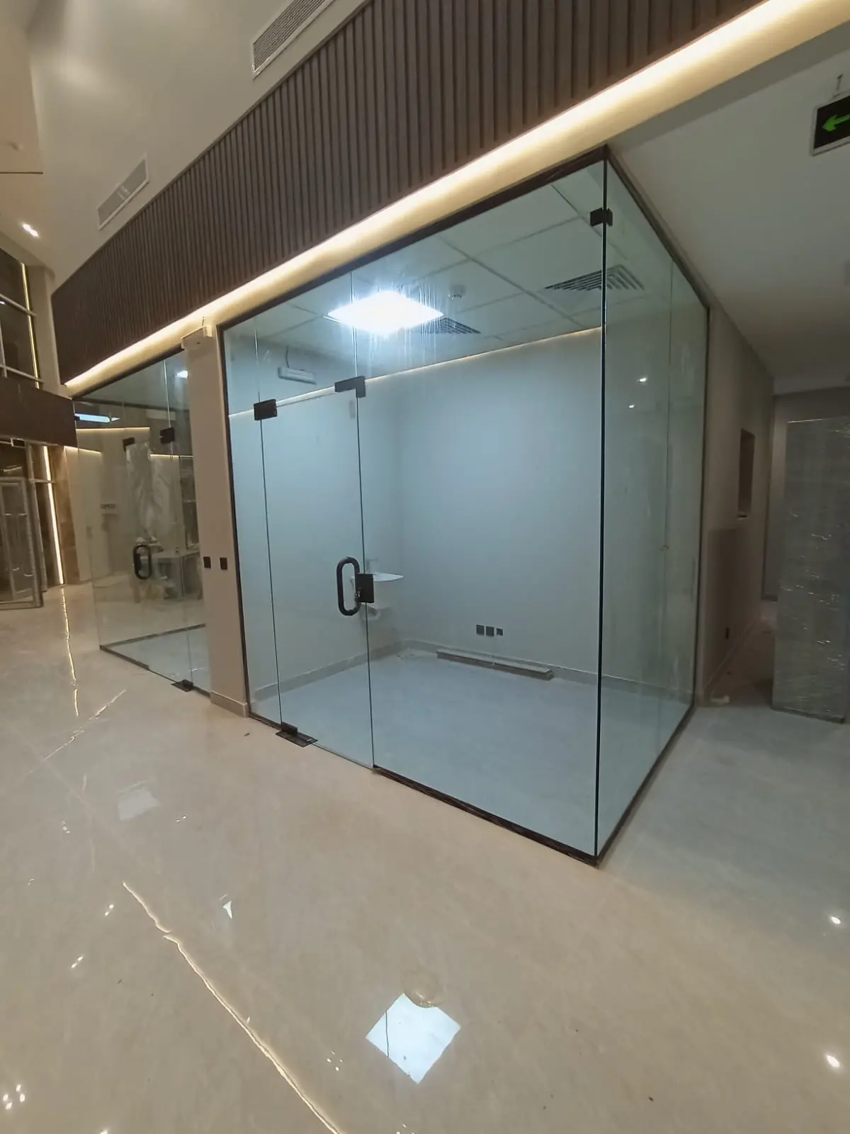 غرفة مكتب زجاجية بباب سيكوريت ومقبض أسود وإكسسوارات في جدة