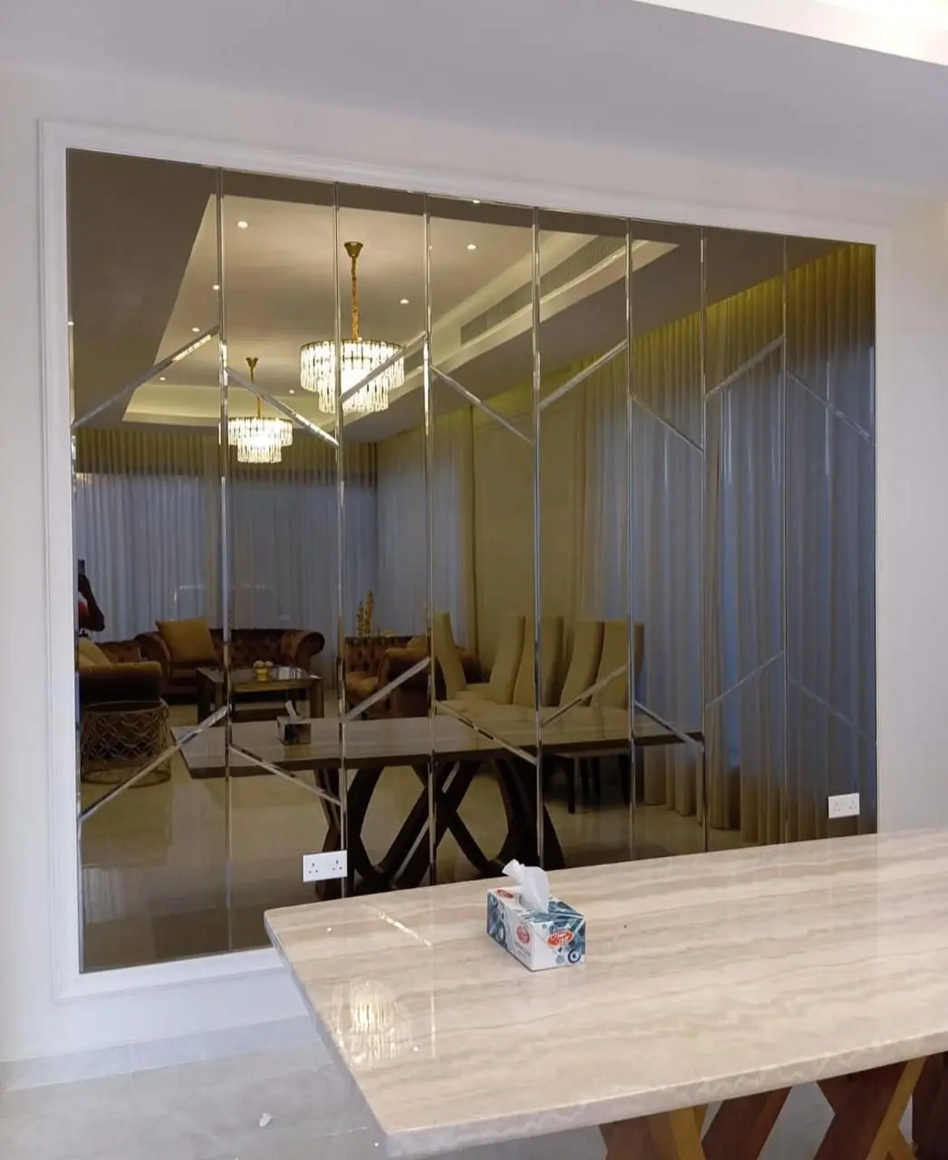 ديكور مرايا حائط كبير مقسم لشرائح مع حفر خطوط هندسية في صالة طعام فاخرة.